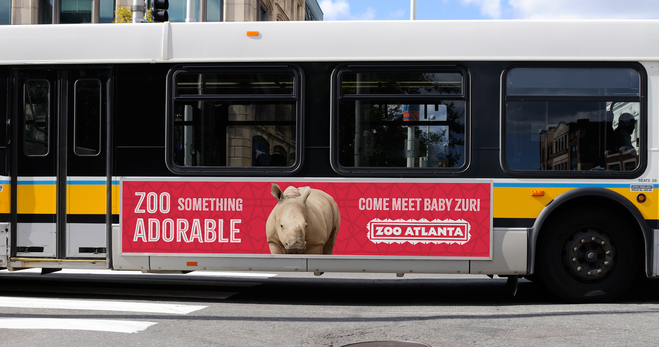 Bus wrap ad featuring a baby rhino and the text "Zoo something adorable."