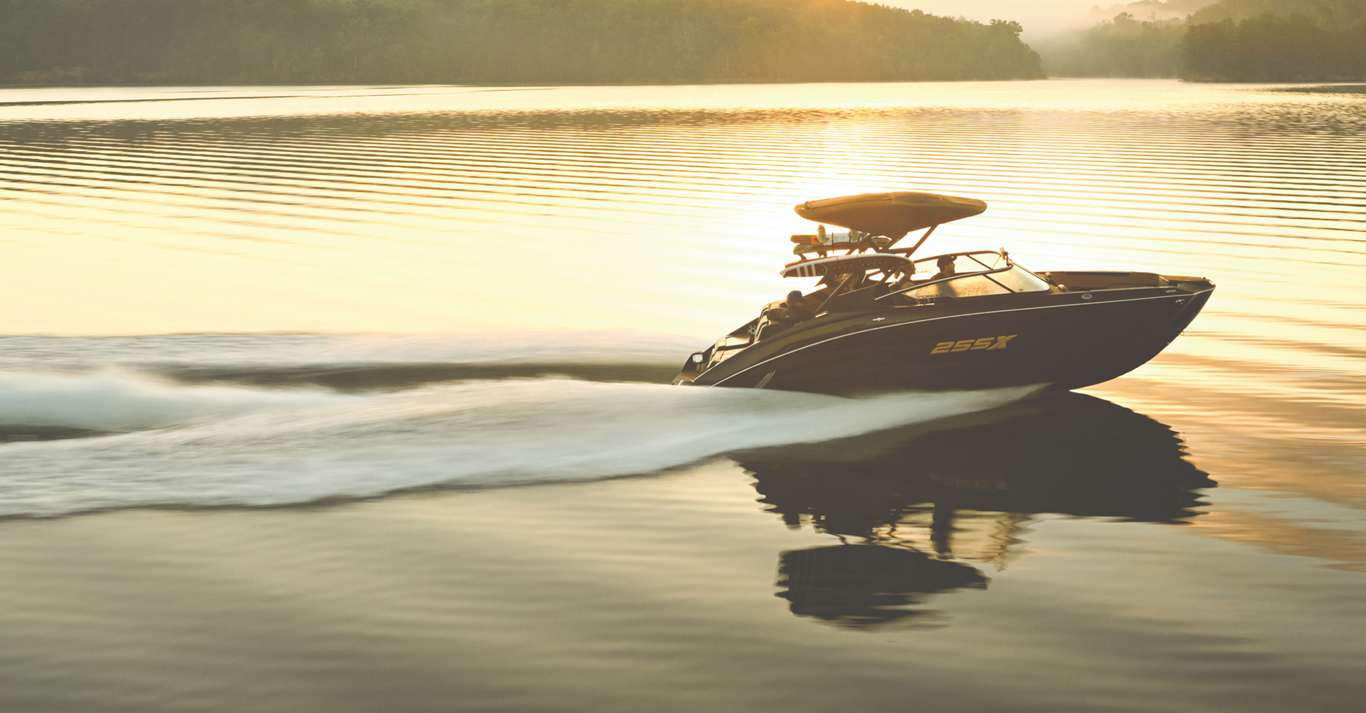 Photograph of a boat gliding on calm water, early morning or sunset light.