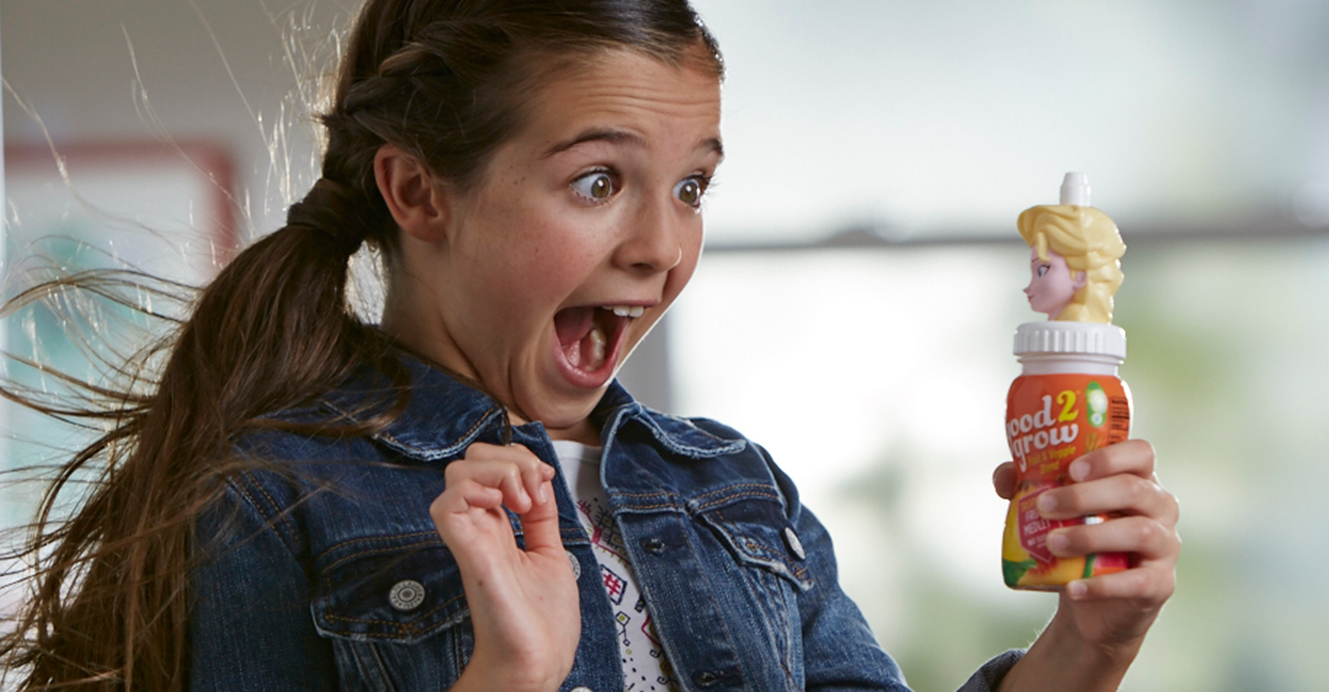 A girl very excited to be holding an Elsa drink.