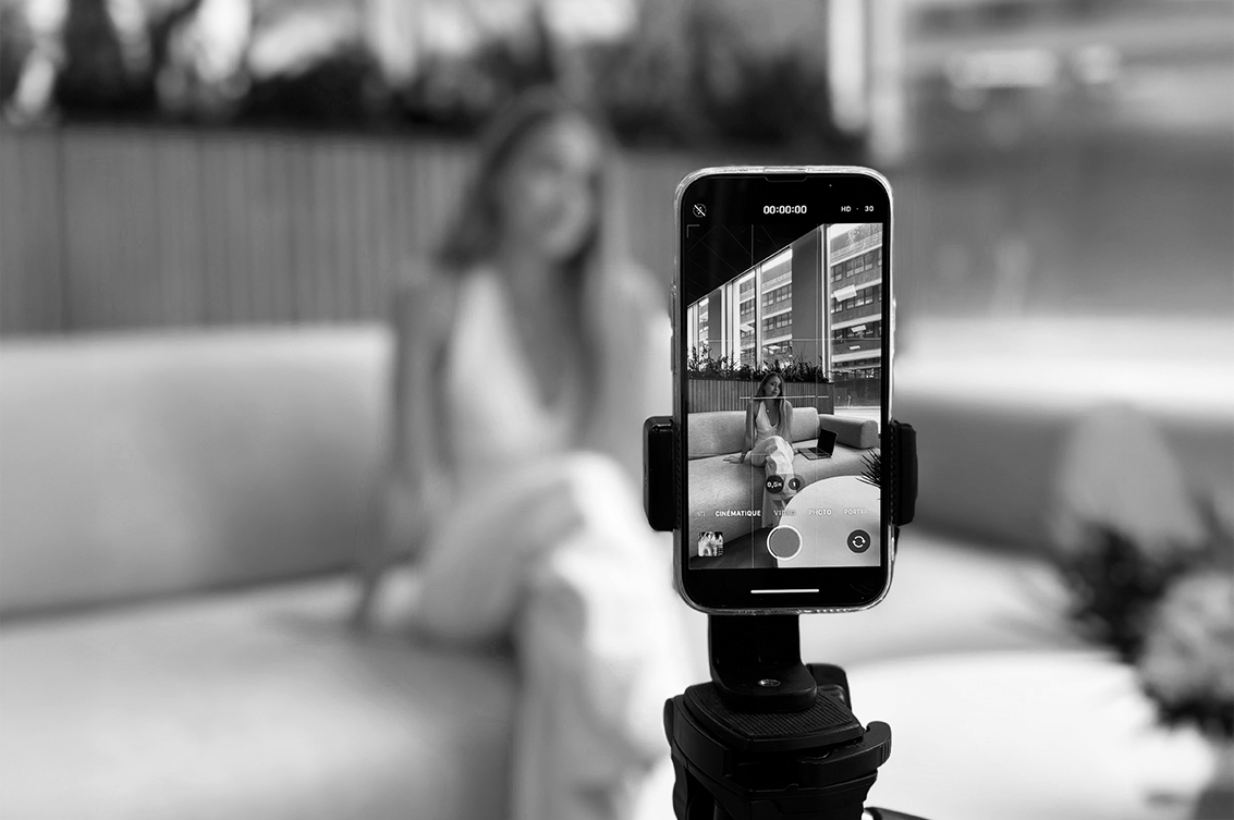 A person sitting on a sofa filming content