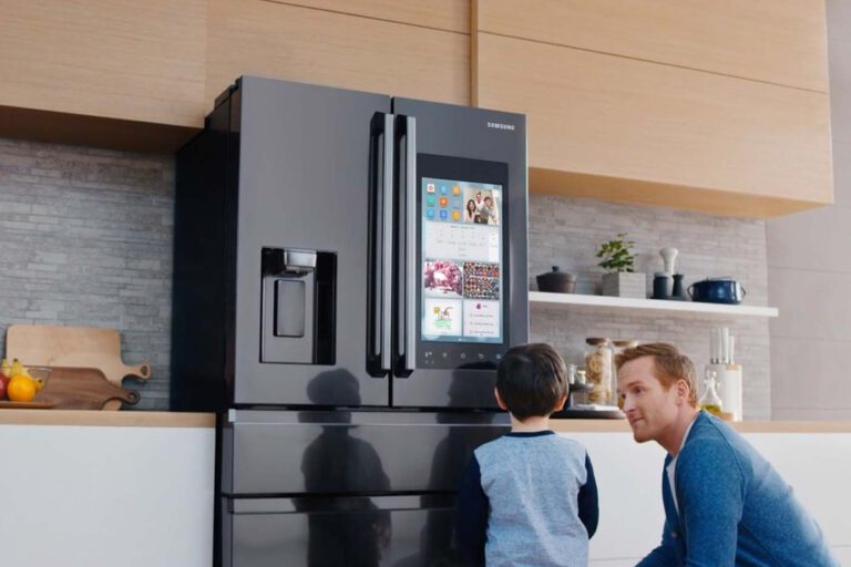 Modern Samsung refrigerator with a touchscreen panel, operated by a father and son.