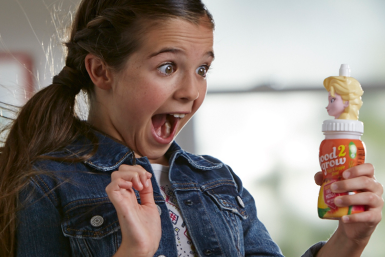 A girl very excited to be holding an Elsa drink.